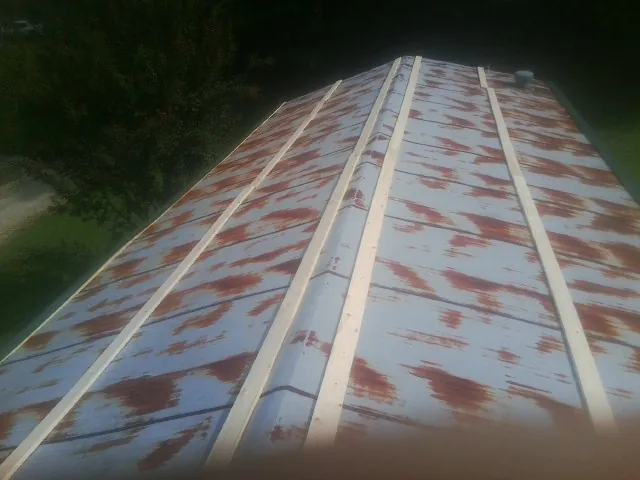 Rusted metal roof panels with new wood purlins before replacement — Storm Damage Roof Repair in Owings by Roofing Brothers